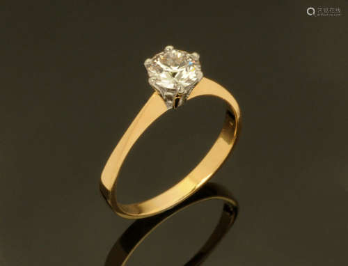 An 18 ct two tone gold solitaire ring, set with a diamond we...