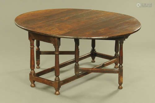 An antique oak twin drop flap gate legged dining table,