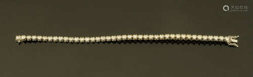 An 18 ct white gold tennis bracelet, set with diamonds weigh...