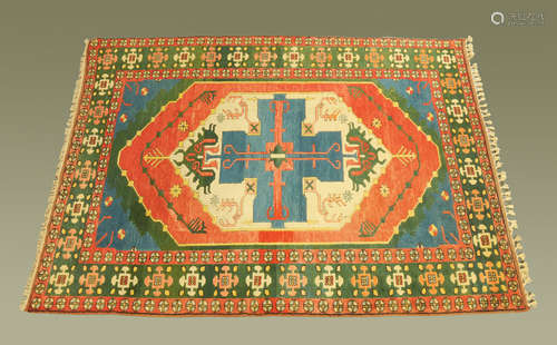 A Turkish wool rug, with fringed ends, principal colours gre...