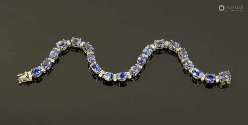 An 18 ct gold tanzanite and diamond set tennis bracelet, dia...