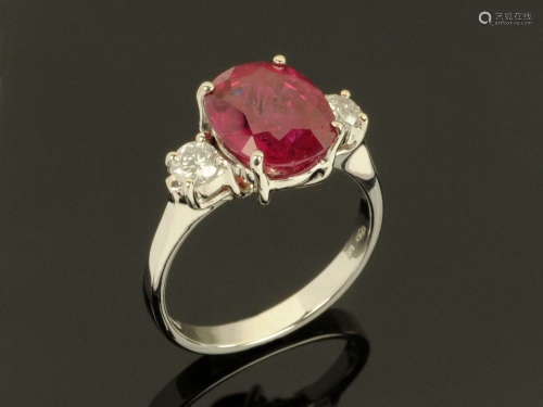 An 18 ct gold oval ruby and diamond three stone ring, ruby 4...