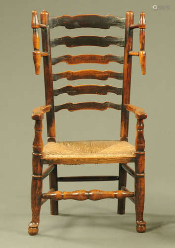 An 19th century wool winder elm ladder back armchair,