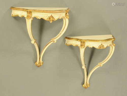 A pair of cream and gilt painted shaped pier tables, with sc...