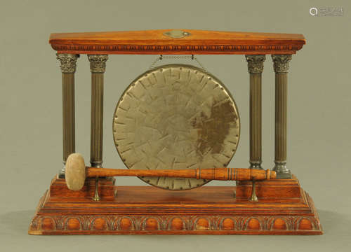 An Edwardian oak table gong, the circular gong flanked by do...