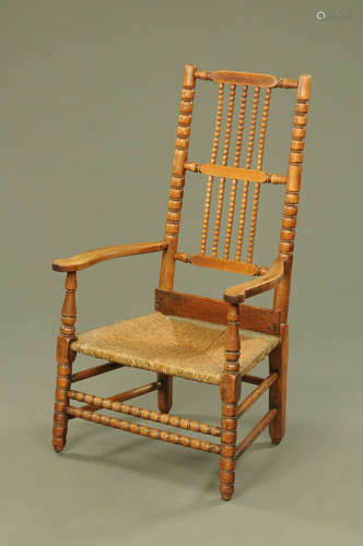 A 19th century bobbin turned rush seated armchair.