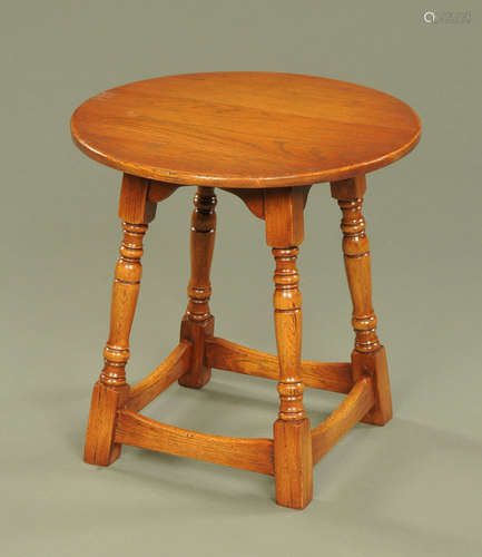 A Chapmans Siesta circular oak occasional table, raised on f...