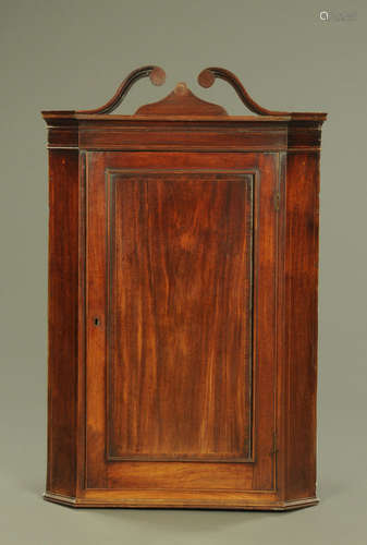 A George III mahogany hanging corner cupboard,