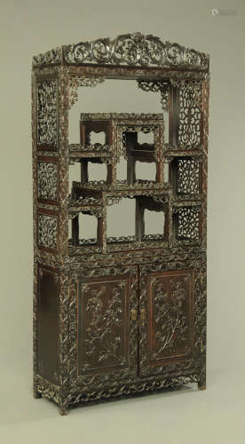 A 19th century Chinese hardwood cabinet in two sections,