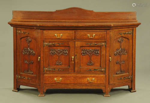 An Art Nouveau oak sideboard, with rear upstand, canted angl...