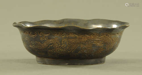 A Chinese bronze dish, decorated with dragons and with chara...