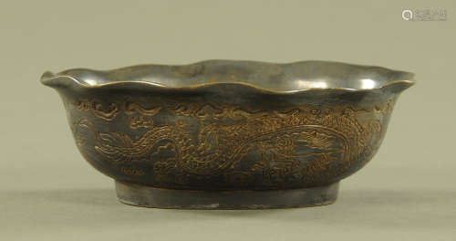 A Chinese bronze dish, decorated with dragons and with chara...