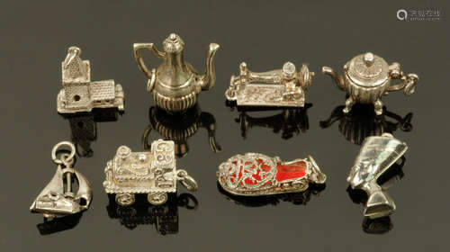 A collection of eight silver charms.