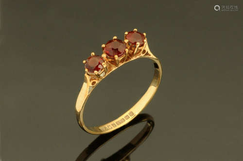 A 9 ct gold three stone garnet ring, Size M.