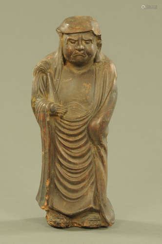 A Japanese terracotta figure of Daruma, in typical standing ...