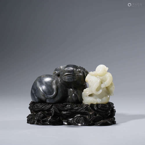 A CHINESE BLACK AND WHITE JADE CARVING OF A RECUMBENT BULL A...