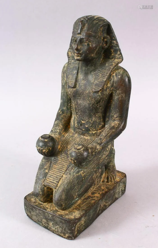 AN EGYPTIAN STONE FIGURE, in a knelt position holding