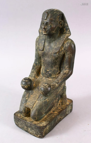 AN EGYPTIAN STONE FIGURE, in a knelt position holding