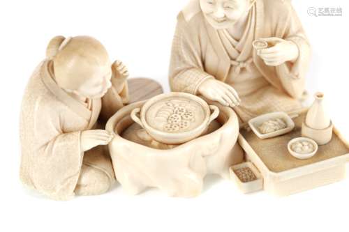 A FINE JAPANESE IVORY CARVING OF A SEATED GROUP, WITH GOLD S...