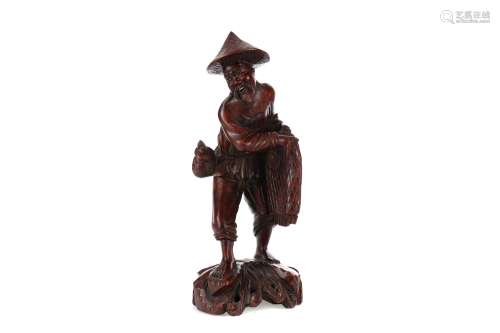 AN EARLY 20TH CENTURY CHINESE CARVED WOOD FIGURE OF A FISHER...