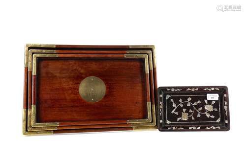 A 20TH CENTURY CHINESE GRADUATED SET OF THREE MAHOGANY TRAYS...