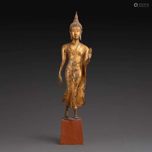 STATUETTE DE BOUDDHA MARCHANTen bronze laqué or, debout, la ...