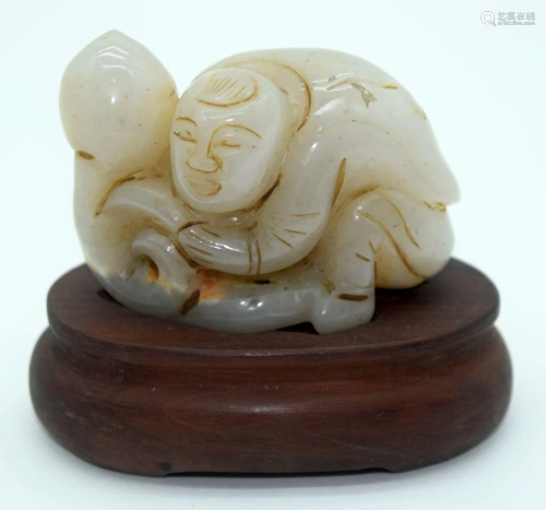 A Carved Jade boulder on a wooden stand in the form of