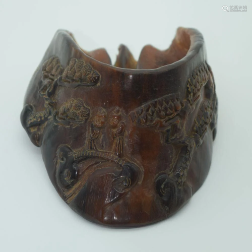 A Chinese carved hoof decorated with figures in a