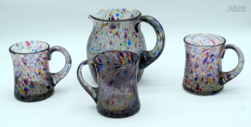 A coloured crackle glass jug and three beakers. 16cm