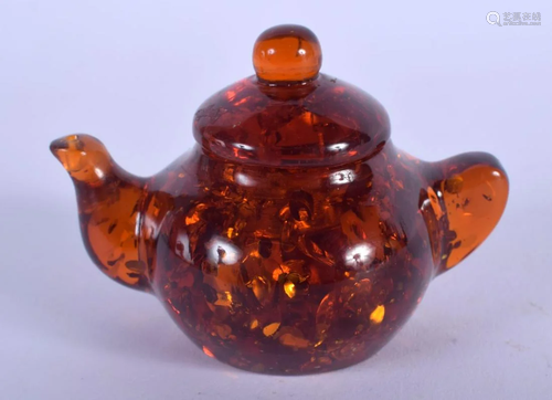 A CHINESE CARVED AMBER TEAPOT AND COVER 20th Century.