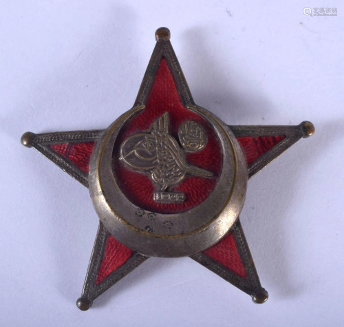 AN UNUSUAL MIDDLE EASTERN BRASS AND ENAMEL STAR BADGE.