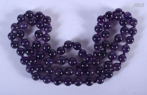 A STRING OF AMETHYST BEADS. 66 cm long.