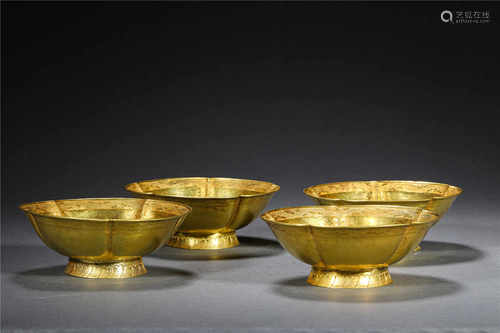 A SET OF FOUR GOLD CUPS OR BOWLS