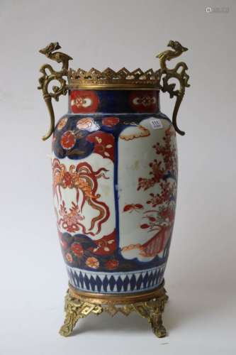 伊玛里。瓷质圆柱形花瓶，以蓝、红、绿、金等色珐琅装饰花和龙。日本，1...