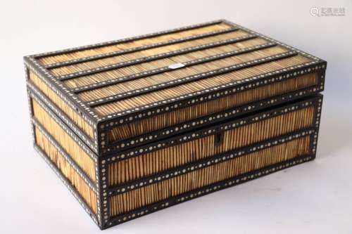黑檀木和豪猪刺的大长方形盒子，镶嵌着骨质的装饰。里面有九个小隔...