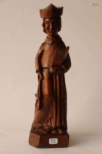 橡木圣器室雕塑，代表着一位戴着三尖塔的主教，手里拿着一本打开的...