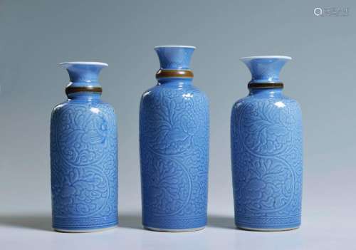 A GROUP OF THREE FINELY CARVED BLUE-GLAZED BOTTLE VASES