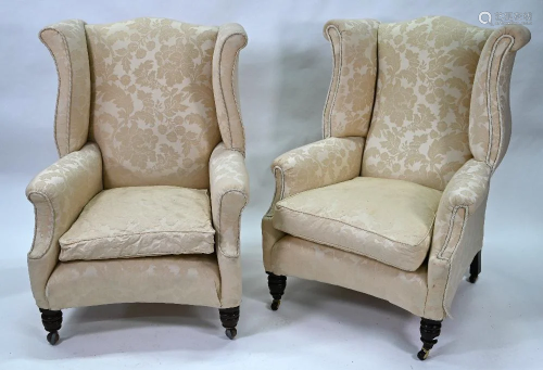 A pair of Georgian style wing armchairs with turned