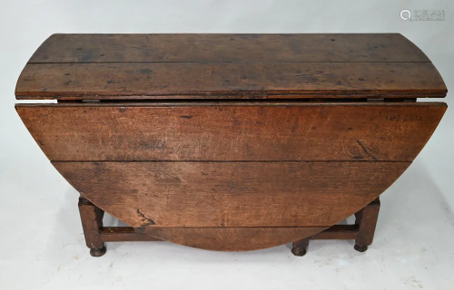 An antique oak gateleg supper table