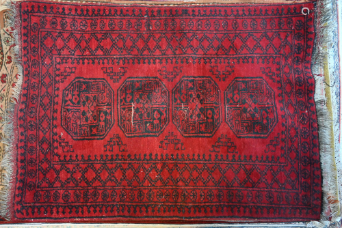 An old Afghan rug with red ground and geometric guls