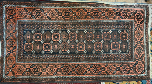 An old Belouch rug, brown and orange