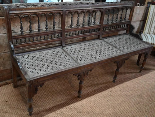 An old Anglo-Indian teak veranda bench with caned