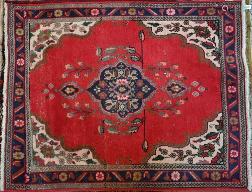 An old Persian Heriz rug with red ground and floral