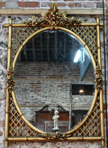 An antique giltwood framed mirror with oval plate