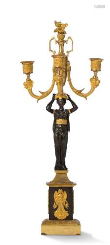 一件青铜火焰杯，有三支灯臂和一个卡利亚特图案。四角形的底座，饰以...