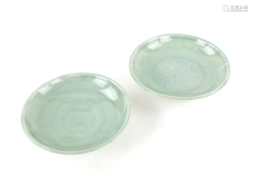 Two Chinese celadon glazed saucer dishes with incised decora...