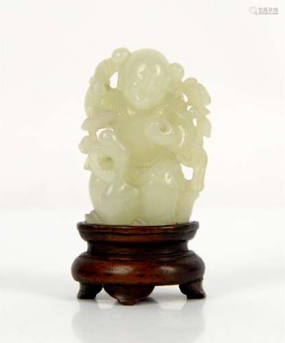 A small Chinese green jade figure of a boy standing beside a...