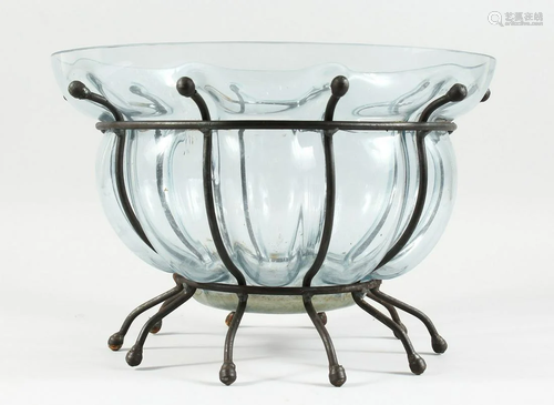 A TINTED SHAPED GLASS BOWL on a wrought iron stand, 13