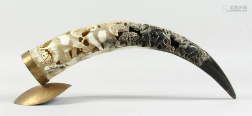 A BOVINE HORN carved with elephants, 18 in. long.
