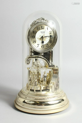 A QUARTZ CLOCK in a domed cover, 11 ins high.